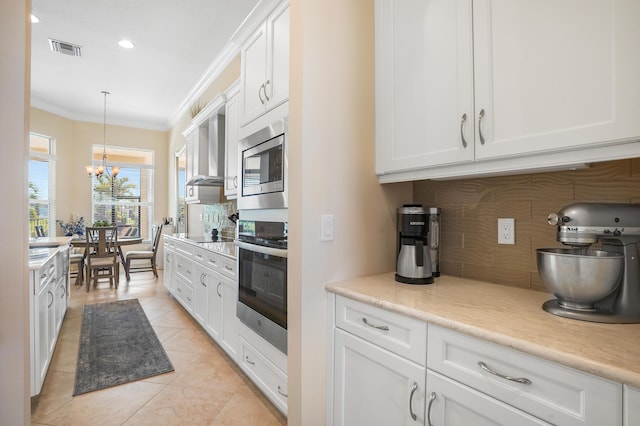 kitchen featuring white cabinetry, hanging light fixtures, crown molding, and appliances with stainless steel finishes