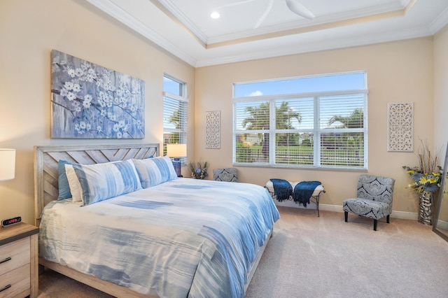 bedroom with a tray ceiling, crown molding, and carpet flooring