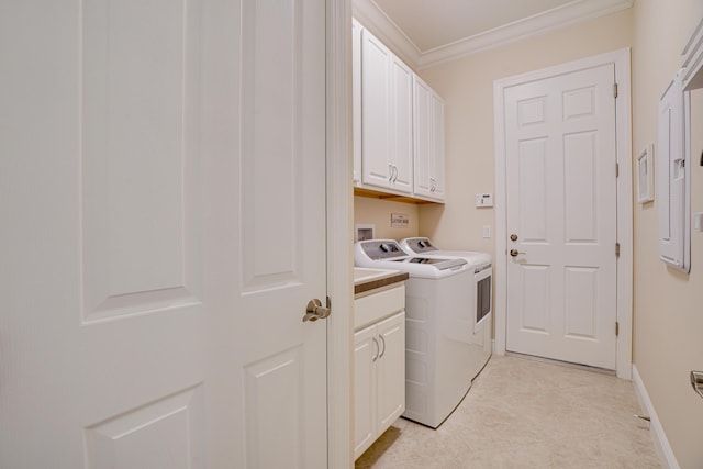 clothes washing area with cabinets, crown molding, and independent washer and dryer