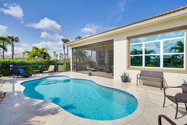 view of pool featuring a sunroom, ceiling fan, and a patio area