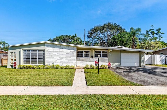 ranch-style home featuring a garage and a front lawn