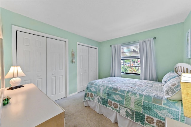 carpeted bedroom featuring multiple closets