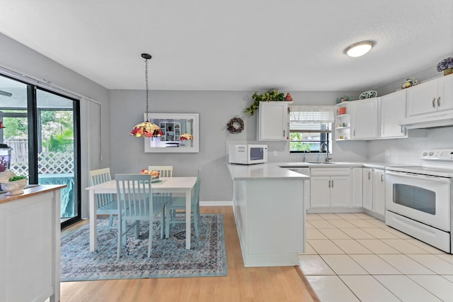 kitchen with sink, white cabinetry, decorative light fixtures, white appliances, and light hardwood / wood-style floors