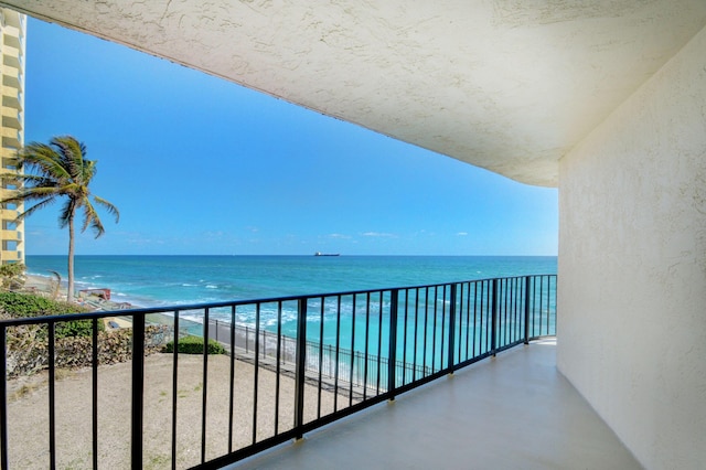 balcony featuring a water view and a view of the beach