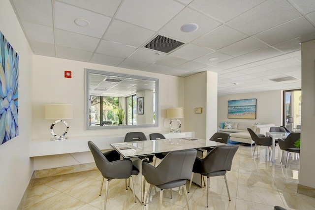 dining space featuring a drop ceiling