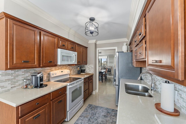 kitchen with pendant lighting, sink, white appliances, tasteful backsplash, and ornamental molding