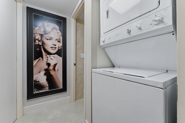 laundry area with light tile patterned floors and stacked washing maching and dryer