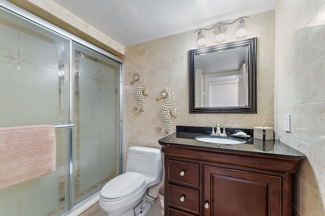 bathroom featuring vanity, tile walls, walk in shower, and toilet