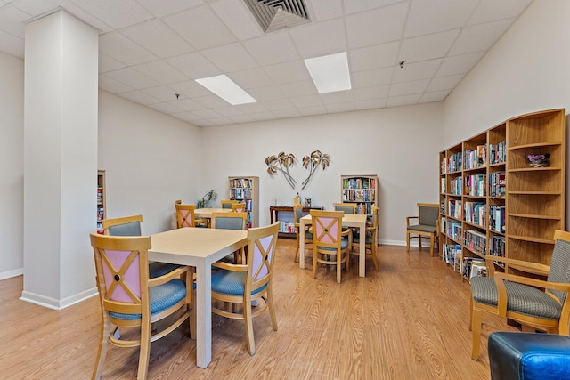 dining room with a paneled ceiling and light hardwood / wood-style floors