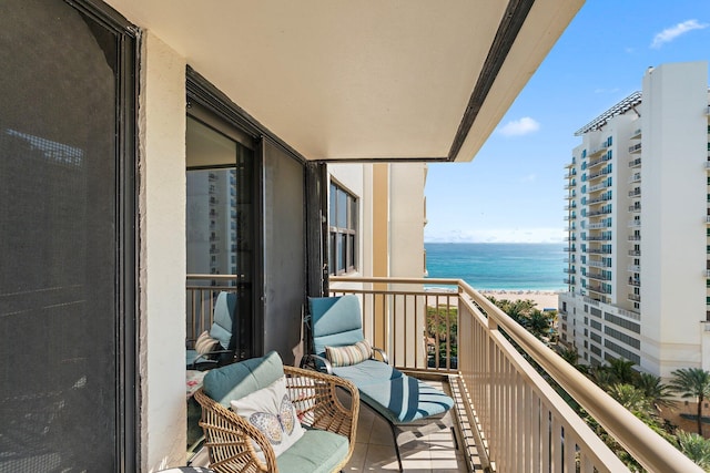 balcony with a water view and a view of the beach