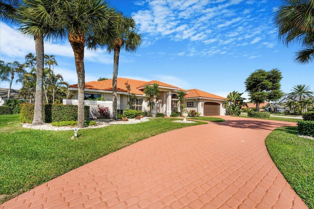 mediterranean / spanish-style house with a garage and a front yard