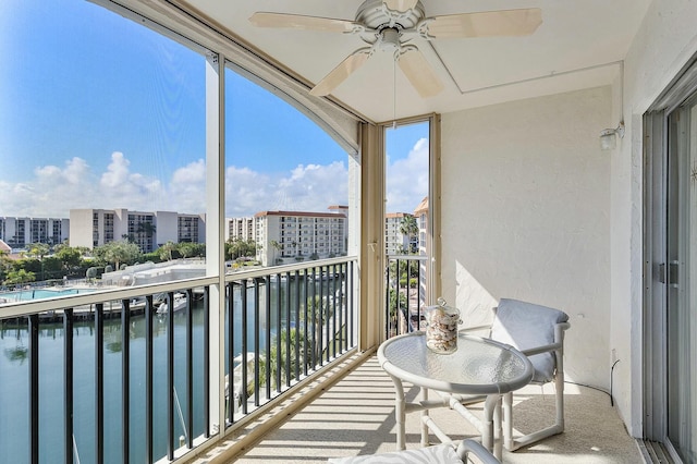 balcony featuring a water view and ceiling fan