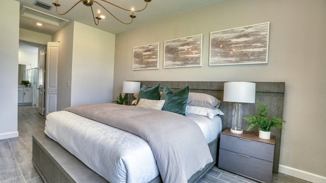 bedroom with an inviting chandelier and hardwood / wood-style floors