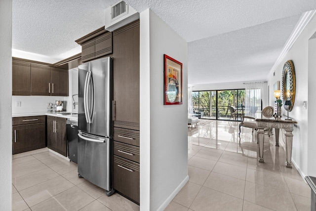 kitchen with stainless steel fridge, black dishwasher, dark brown cabinetry, ornamental molding, and light tile patterned flooring