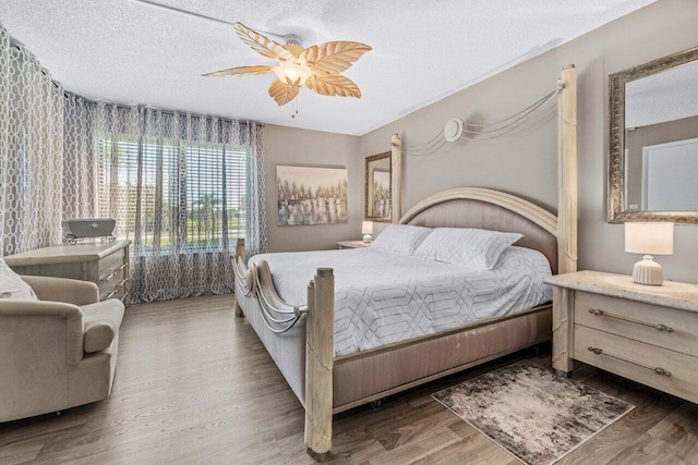 bedroom with ceiling fan, dark hardwood / wood-style floors, and a textured ceiling