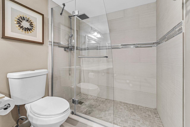 bathroom featuring walk in shower and toilet