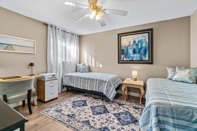 bedroom featuring ceiling fan, a textured ceiling, and light wood-type flooring