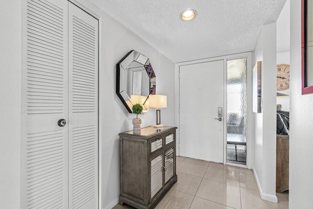 entrance foyer featuring a textured ceiling and light tile patterned flooring