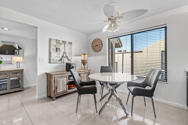 tiled dining area featuring a textured ceiling and ceiling fan