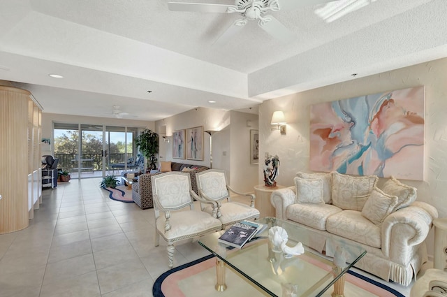 living room featuring a textured ceiling, ceiling fan, and light tile patterned flooring