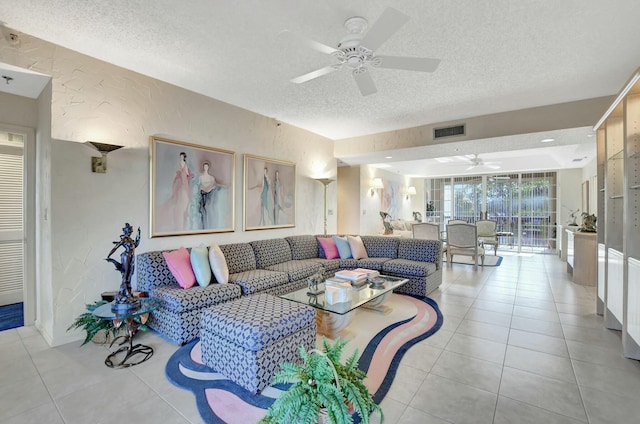 living room with ceiling fan, a textured ceiling, and light tile patterned floors