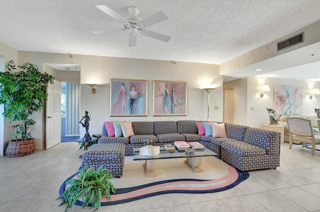 living room featuring ceiling fan, light tile patterned floors, and a textured ceiling