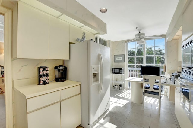 kitchen featuring light tile patterned floors, white appliances, cream cabinetry, and ceiling fan