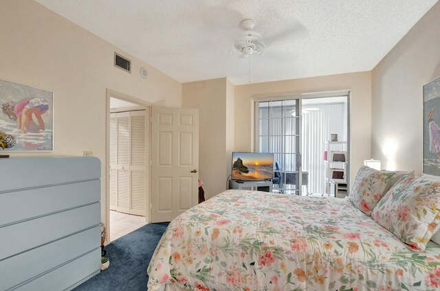 bedroom with ceiling fan, a closet, a textured ceiling, and dark colored carpet