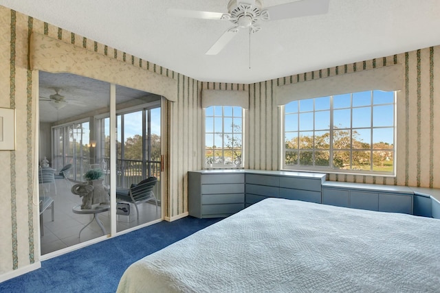 bedroom with access to exterior, dark carpet, a textured ceiling, and ceiling fan