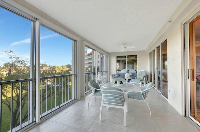 unfurnished sunroom with ceiling fan