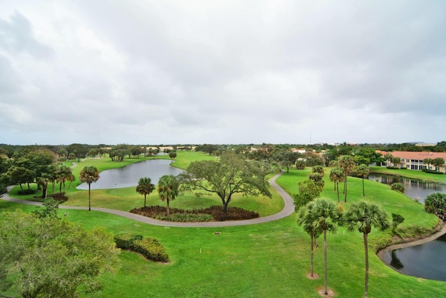 view of property's community with a water view and a lawn