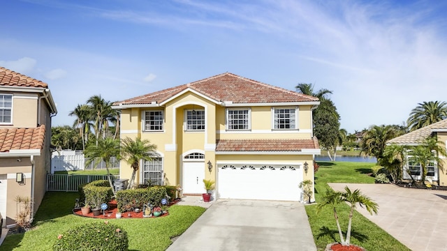 mediterranean / spanish home with a garage, a water view, and a front yard