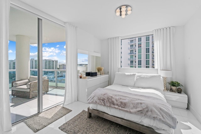 bedroom with light tile patterned flooring, access to outside, and a wall of windows