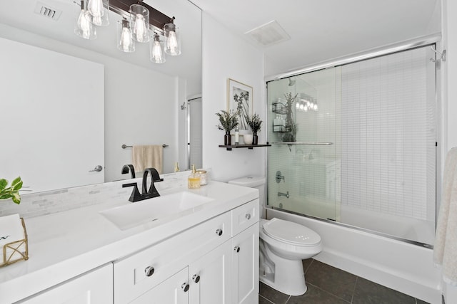 full bathroom featuring tile patterned flooring, vanity, shower / bath combination with glass door, and toilet