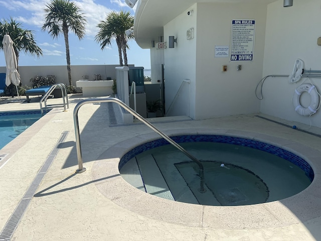 view of swimming pool with a community hot tub and a patio area