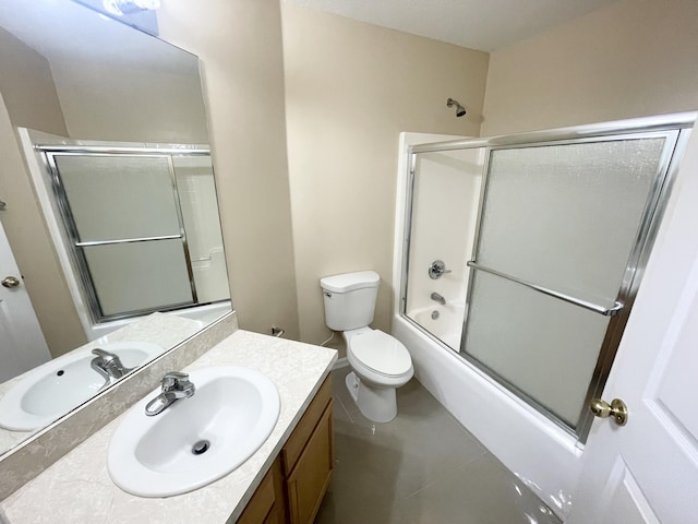 full bathroom with tile patterned flooring, vanity, shower / bath combination with glass door, and toilet