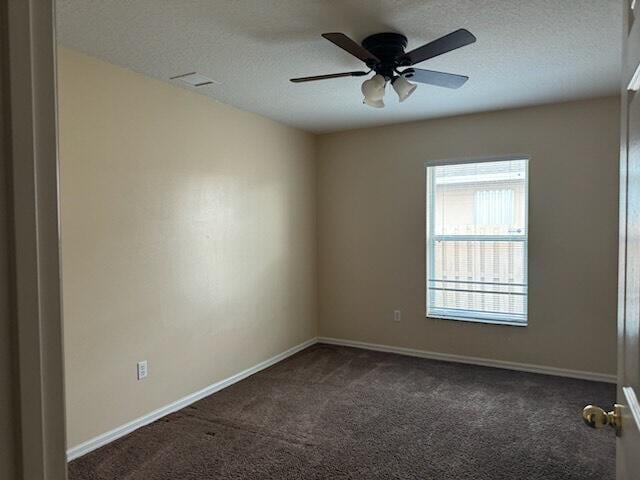 unfurnished room featuring ceiling fan, a textured ceiling, and dark colored carpet