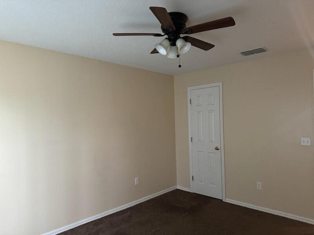 unfurnished room with ceiling fan and dark carpet