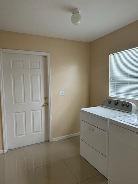 laundry area featuring washing machine and clothes dryer and light tile patterned floors