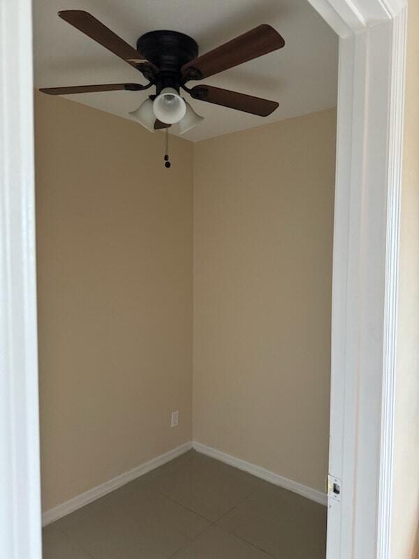 empty room with ceiling fan and tile patterned floors