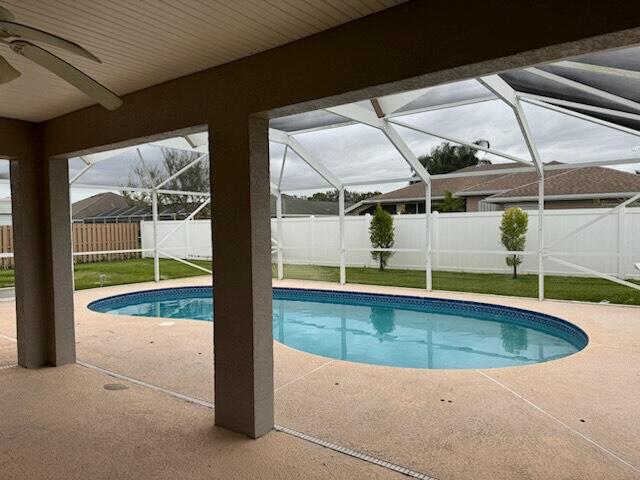 view of pool with a patio area and glass enclosure