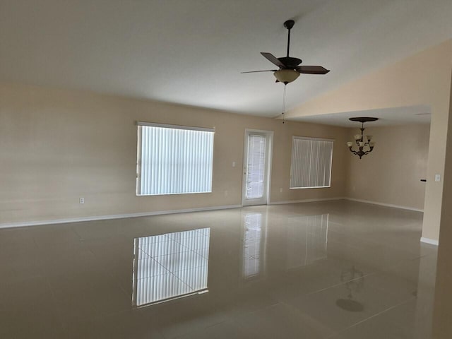 spare room with tile patterned flooring, lofted ceiling, and ceiling fan with notable chandelier