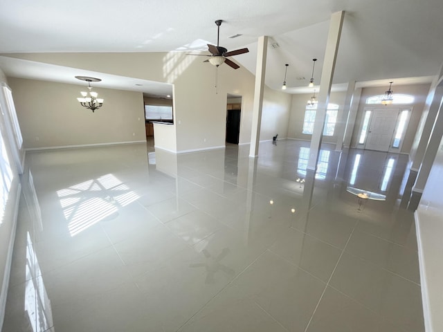 spare room featuring light tile patterned flooring, ceiling fan with notable chandelier, and high vaulted ceiling