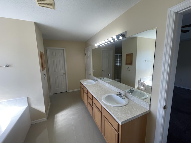 bathroom with vanity, tile patterned flooring, shower with separate bathtub, and a textured ceiling