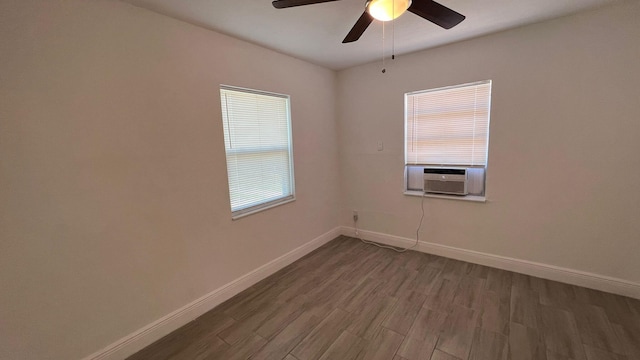 empty room featuring dark wood-type flooring, cooling unit, and ceiling fan