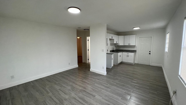 kitchen with white cabinetry, sink, and dark wood-type flooring