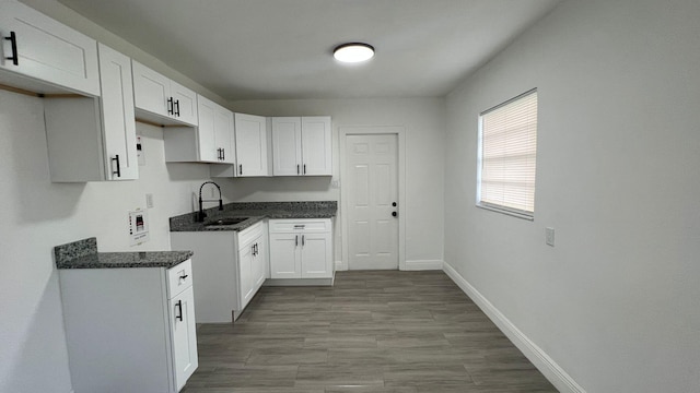 kitchen featuring light hardwood / wood-style floors, sink, and white cabinets