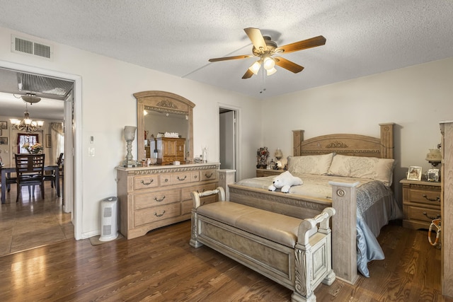 bedroom featuring dark hardwood / wood-style flooring, ceiling fan with notable chandelier, and a textured ceiling