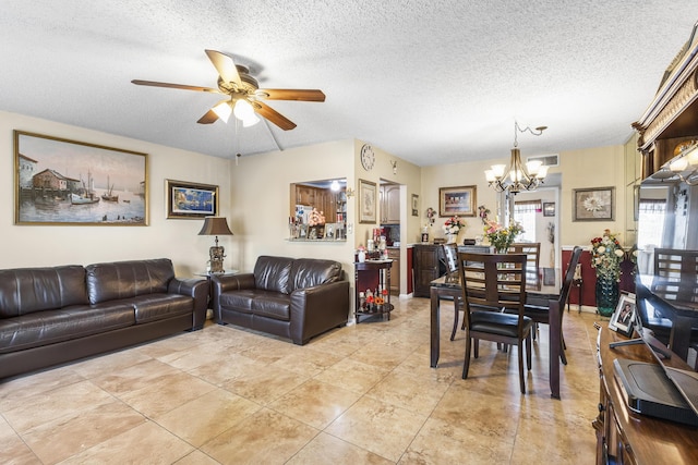 tiled living room with ceiling fan with notable chandelier and a textured ceiling