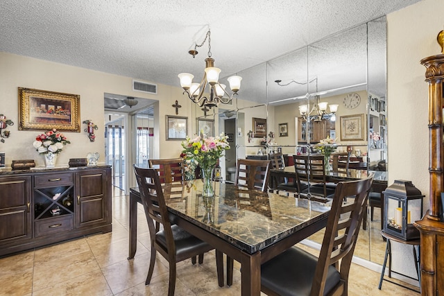 dining area featuring light tile patterned floors, a textured ceiling, and a chandelier